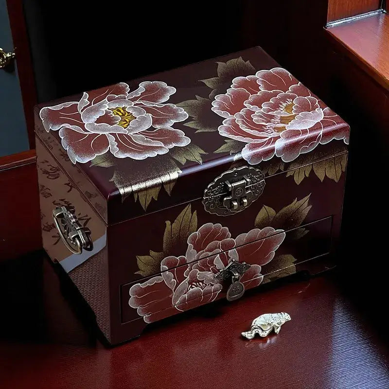 Decorative jewelry box with floral designs on a wooden surface