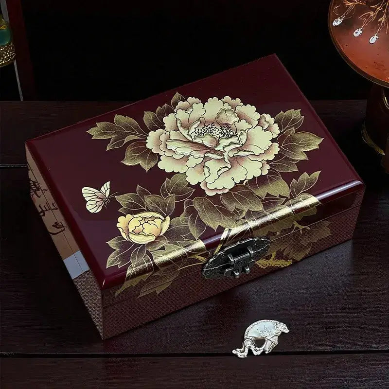Decorative jewelry box with floral design on a dark surface