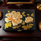 Decorative box with floral design on a wooden surface