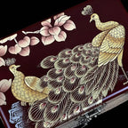 Decorative box with peacock and floral design on a dark background