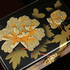 Decorative box with gold floral design on a black background
