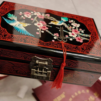 Decorative jewelry box with floral and bird design on a white surface