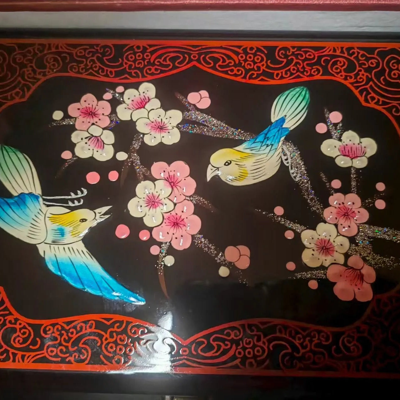 Decorative panel with birds and flowers on a black background