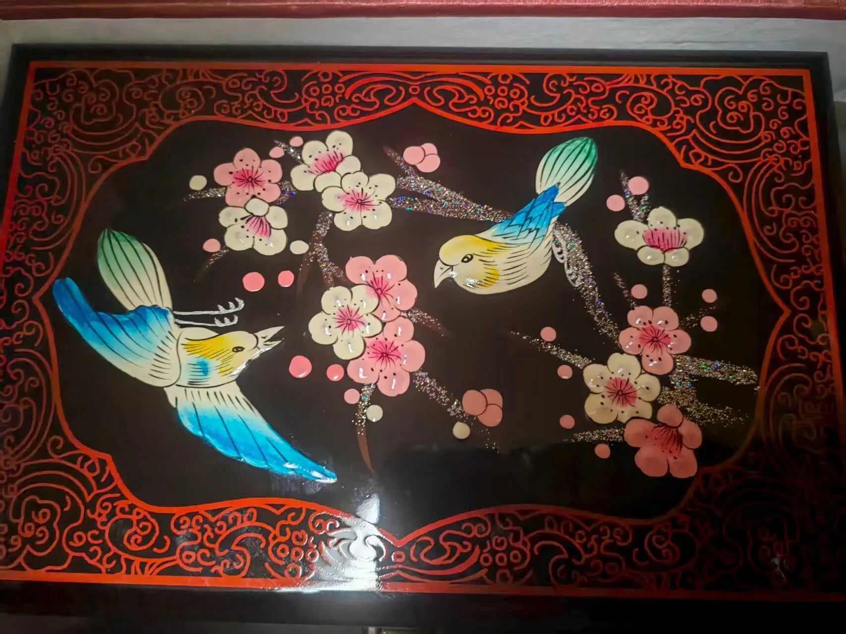Decorative panel with birds and flowers on a black background