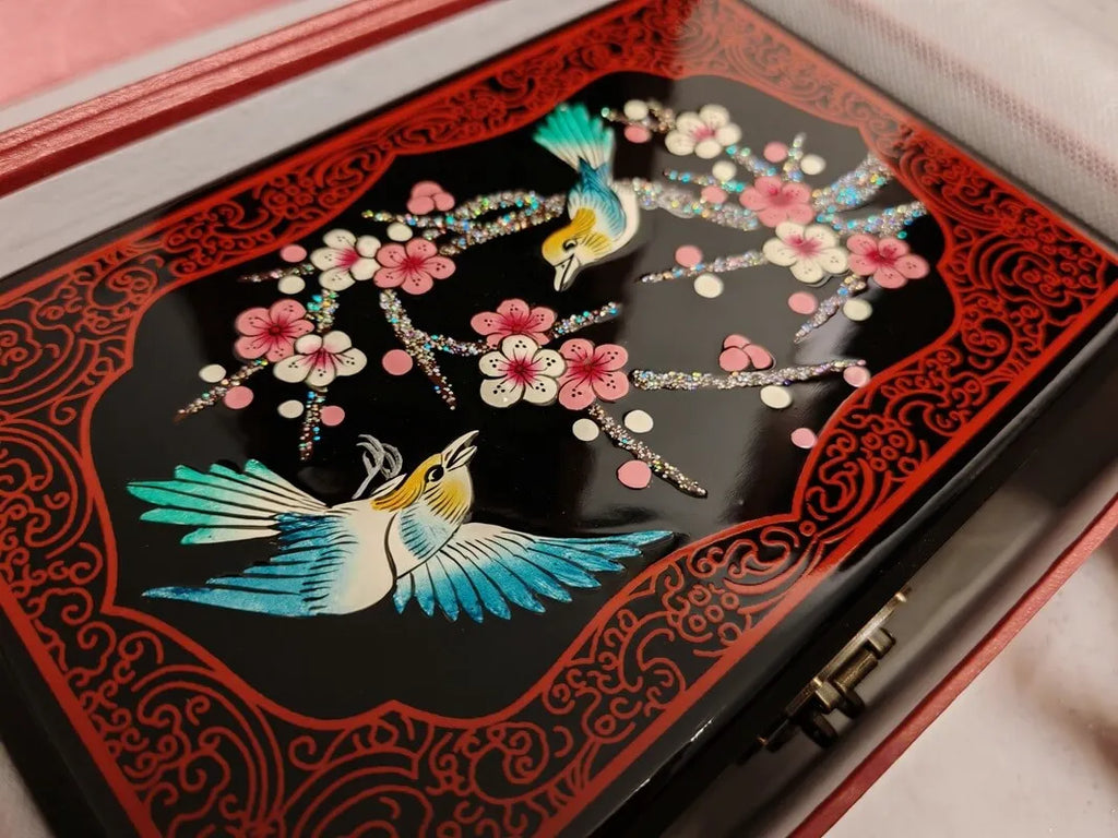 Decorative box with bird and floral design on a black background