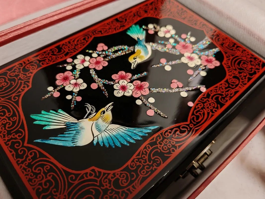 Decorative box with bird and floral design on a black background