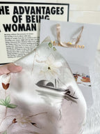 Silk pillowcase with floral design held over a magazine