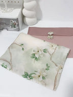Floral-patterned fabric with a pink envelope on a white surface