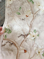 Floral patterned fabric with white flowers and green leaves on a textured beige background.
