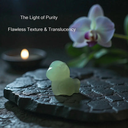 Translucent green stone sculpture on a dark surface with a candle and orchid in the background.
