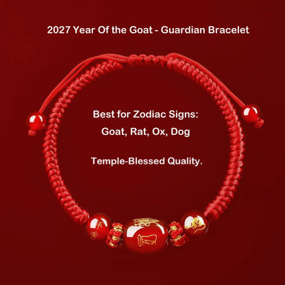 A red braided cord bracelet with glossy red beads and small gold decorative accents, shown on a dark red background with white promotional text about the 2027 Year of the Goat and guardian bracelet design.