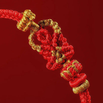 Close-up of a red and gold decorative knot on a red background