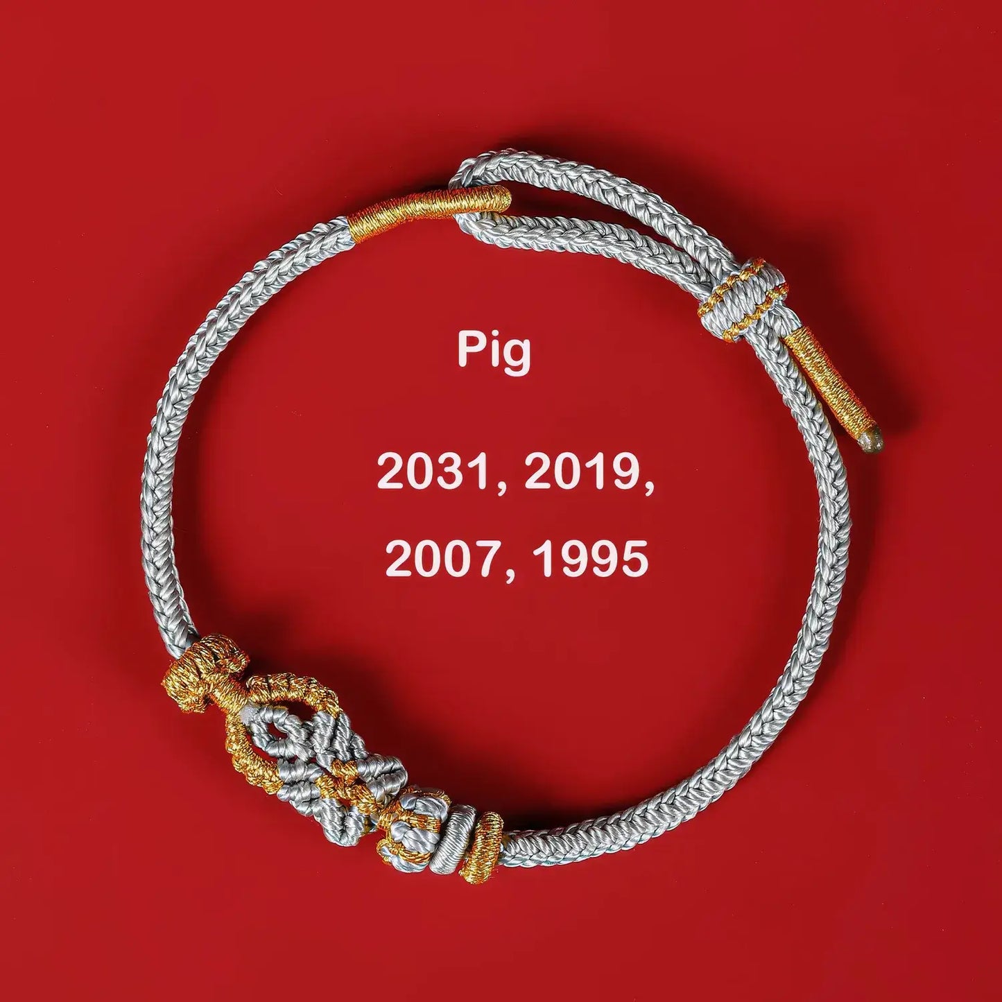 Bracelet with gold and silver accents on a red background, featuring years associated with the pig.