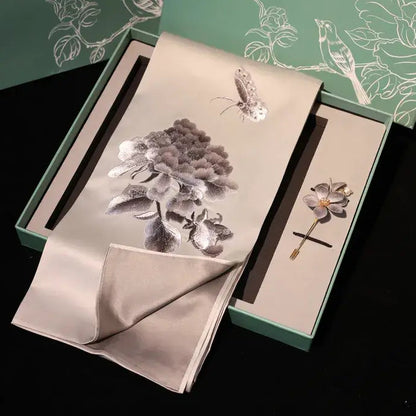 Floral brooch and handkerchief set with matching box on a dark background