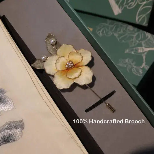 Handcrafted brooch with floral design on a matching box