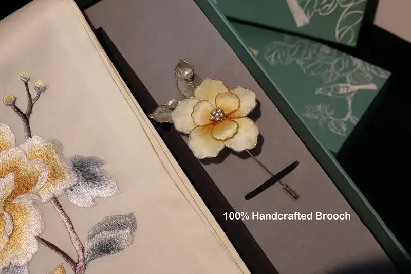 Handcrafted brooch with floral design on a matching box