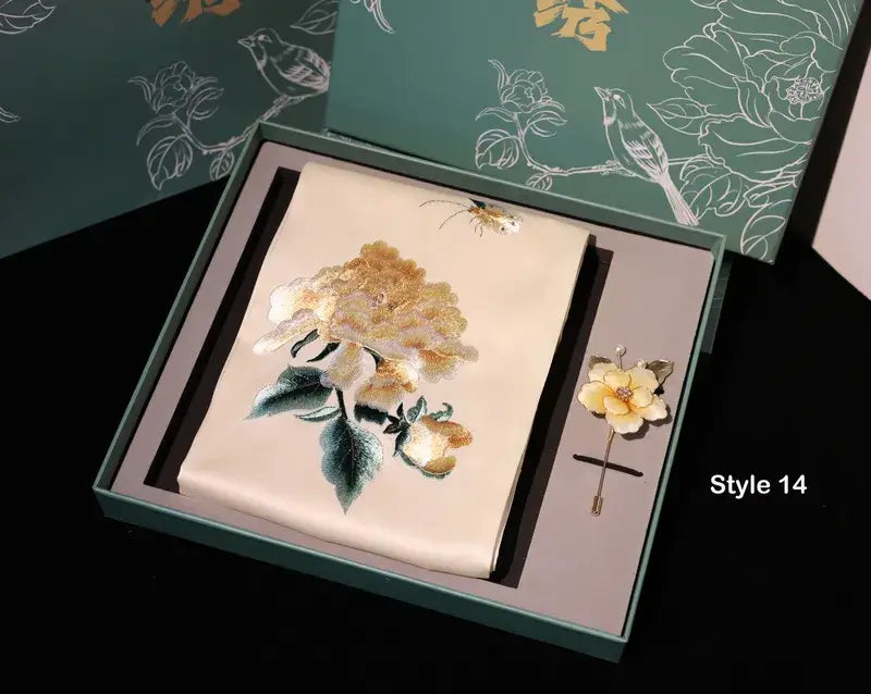 Embroidered floral design on a card with a matching brooch in a decorative box.