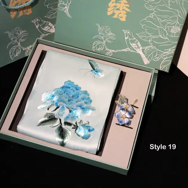 Floral design card and brooch set in a decorative box with floral patterns on the packaging.