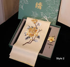 Embroidered fabric with floral design on a black surface, with a green box in the background.