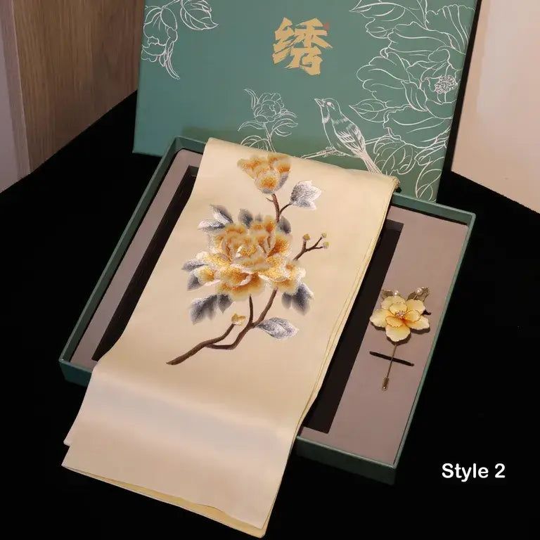 Embroidered fabric with floral design on a black surface, with a green box in the background.