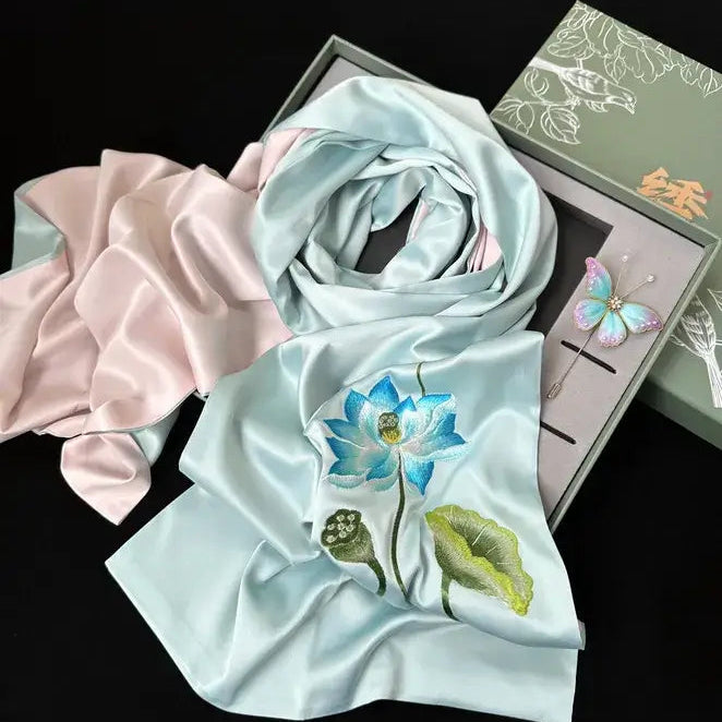 Light blue scarf with floral embroidery on a black background