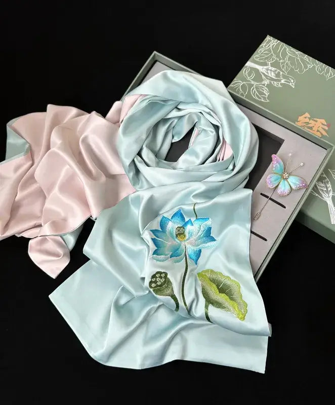 Light blue scarf with floral embroidery on a black background