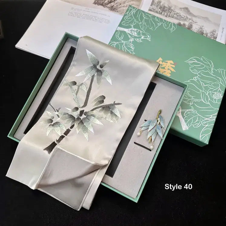 Brooch with floral design in a green box on a dark surface