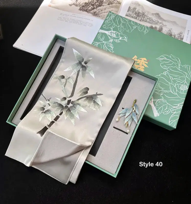 Brooch with floral design in a green box on a dark surface