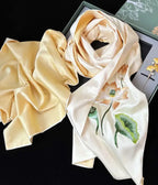 Beige scrunchie and floral scarf on a black background