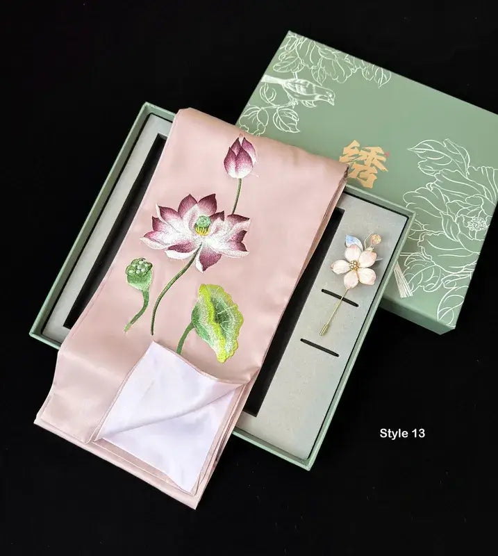 Embroidered pink fabric with floral design in a green box on a black background