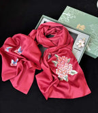 Red scarf with floral and butterfly embroidery on a black background