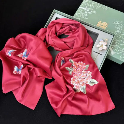 Red scarf with floral and butterfly embroidery on a black background