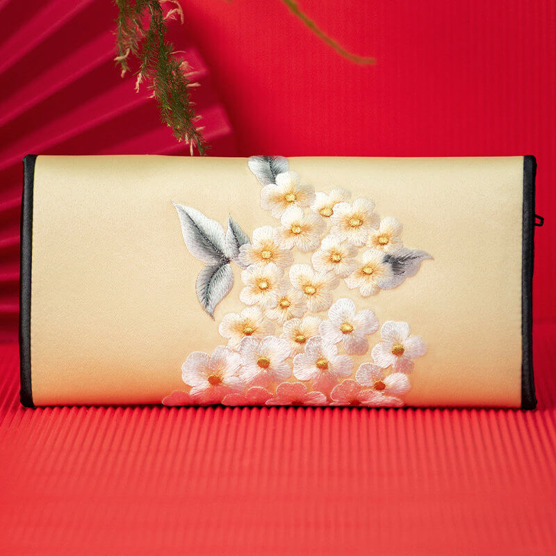 Embroidered clutch with floral design on a red background