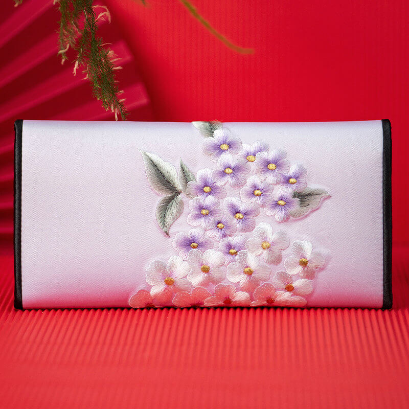 Floral embroidered clutch bag on a red background