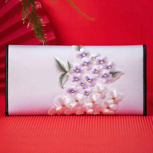 Floral embroidered clutch bag on a red background