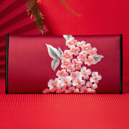 Red pouch with floral embroidery on a red background