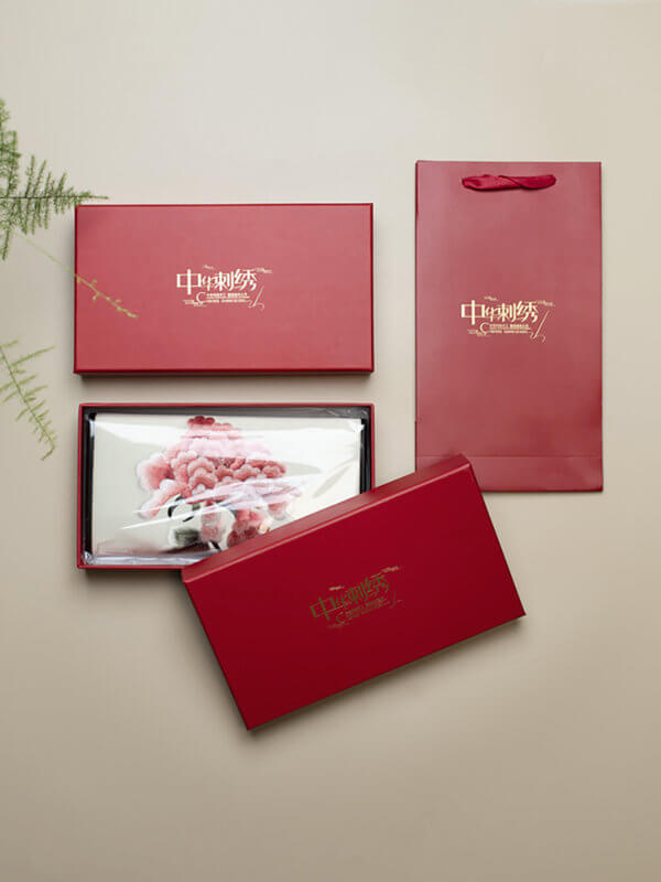 Set of red gift boxes with visible brand logo on a beige background