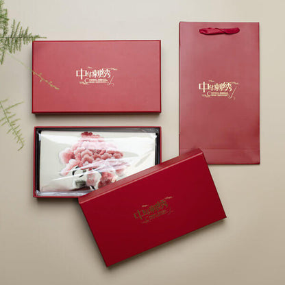 Set of red gift boxes with visible brand logo on a beige background
