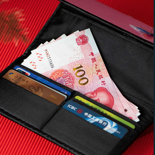 Black wallet with banknotes and cards on a red background
