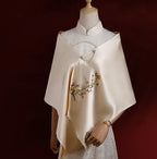 White embroidered shawl on a mannequin against a dark background