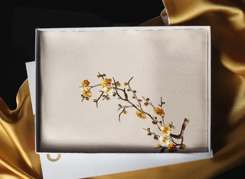 Decorative box with floral design on a gold fabric background