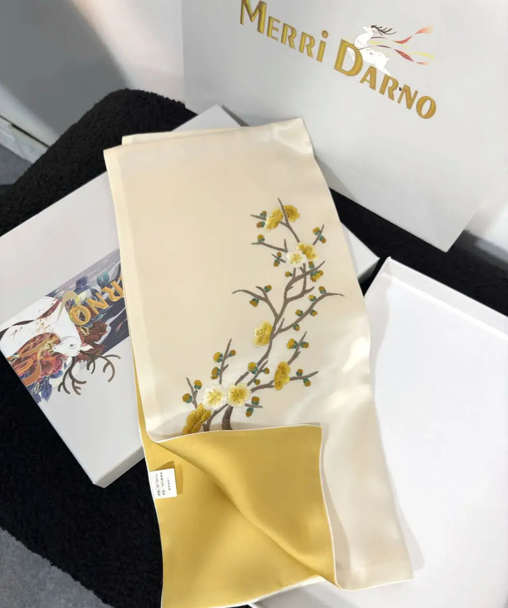 Embroidered fabric with floral design on a white background, featuring the brand 'Merri Darno'.