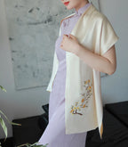 Woman wearing a light purple dress with a beige scarf featuring floral embroidery.