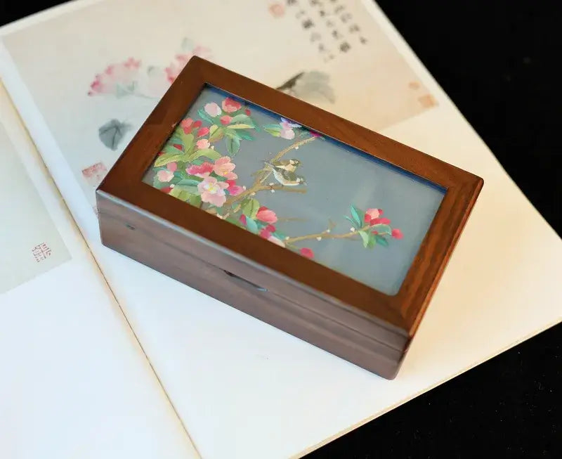 Wooden jewelry box with floral design on a white surface