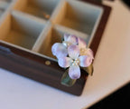 Floral hair clip with pearls on a wooden box