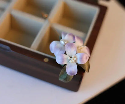 Floral hair clip with pearls on a wooden box