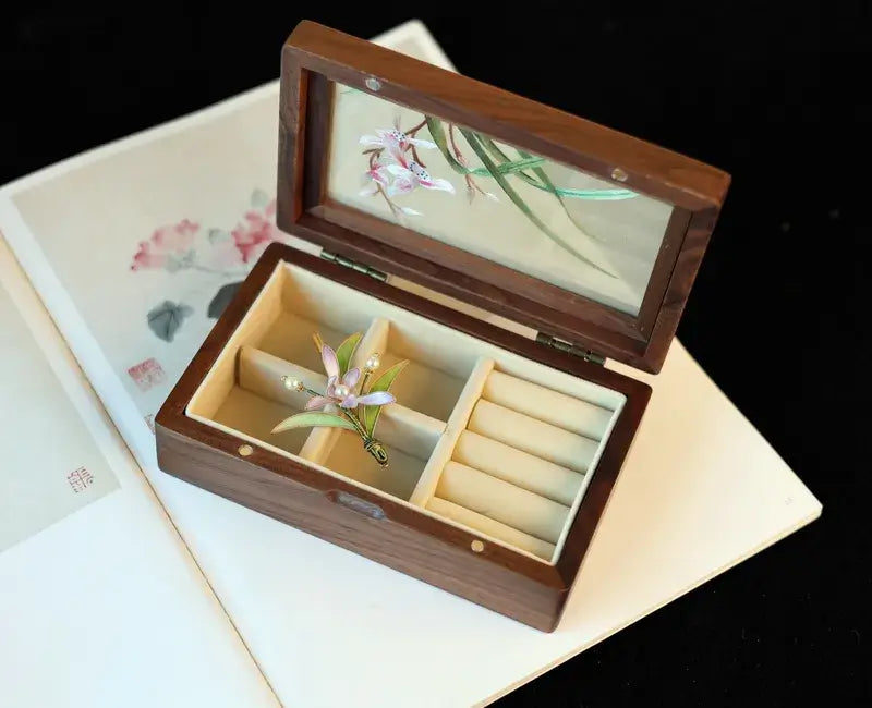 Wooden jewelry box with floral design on a black background