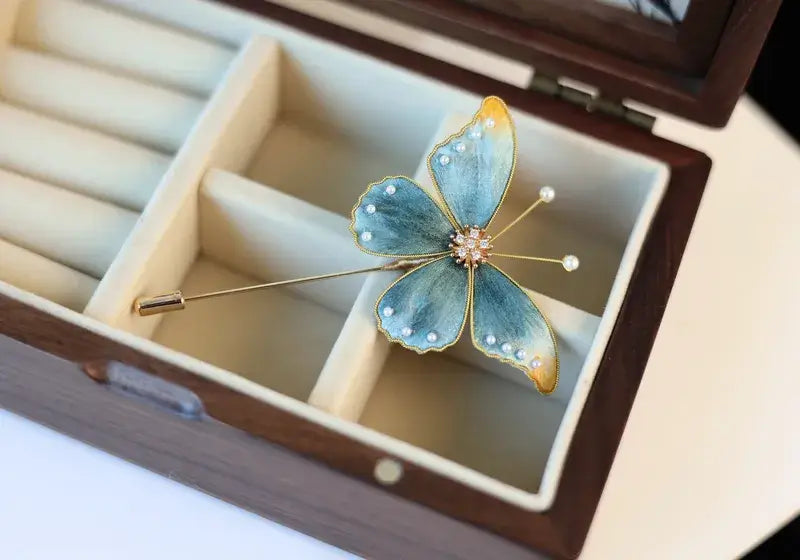 Butterfly-shaped brooch in a wooden jewelry box