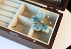 Butterfly-shaped brooch in a wooden jewelry box