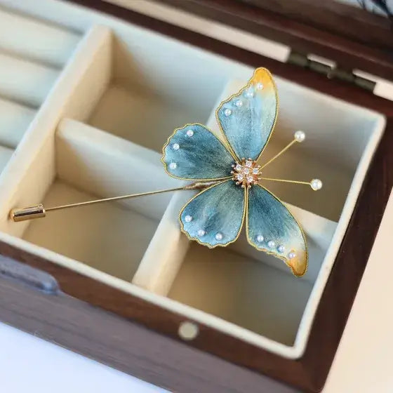 Butterfly-shaped brooch in a wooden jewelry box